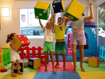 Kinder spielen mit bunten Würfeln in einem Spielzimmer.