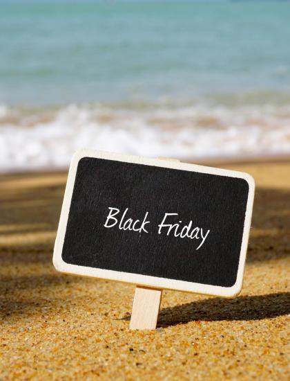 Lavagna Black Friday su spiaggia soleggiata con mare.