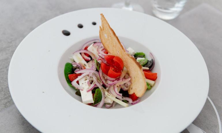 Frischer Salat mit Tomaten, Zwiebeln, Käse und Crouton.