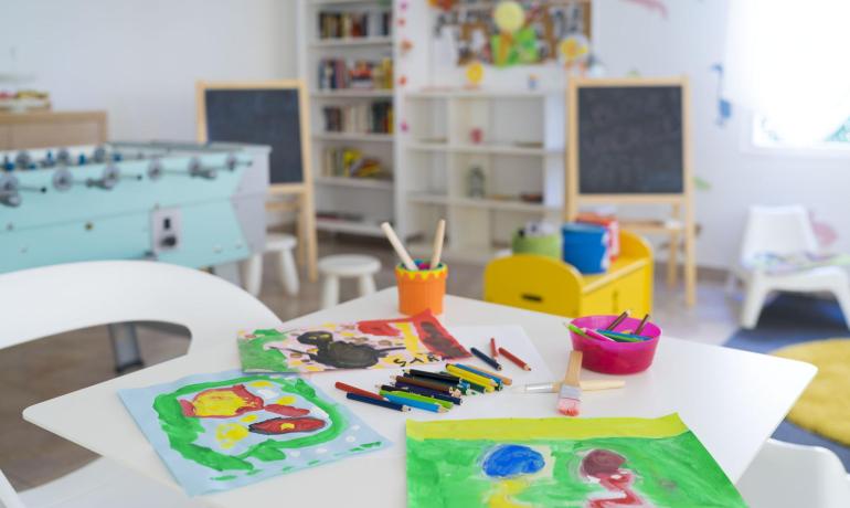 Aula colorata con dipinti e giochi per bambini.