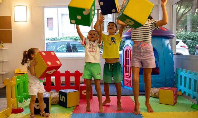 Bambini giocano con cubi colorati in una stanza giochi.