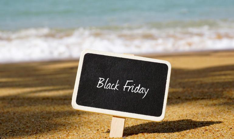 Lavagna Black Friday su spiaggia soleggiata con mare.