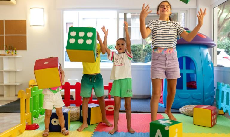 Bambini giocano con cubi colorati in una stanza giochi.