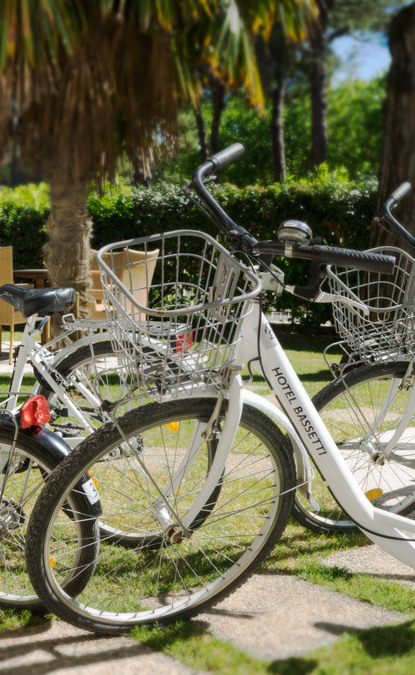 Madre e figlio in bici, sorridenti, indossano caschi per sicurezza, momento di gioia.