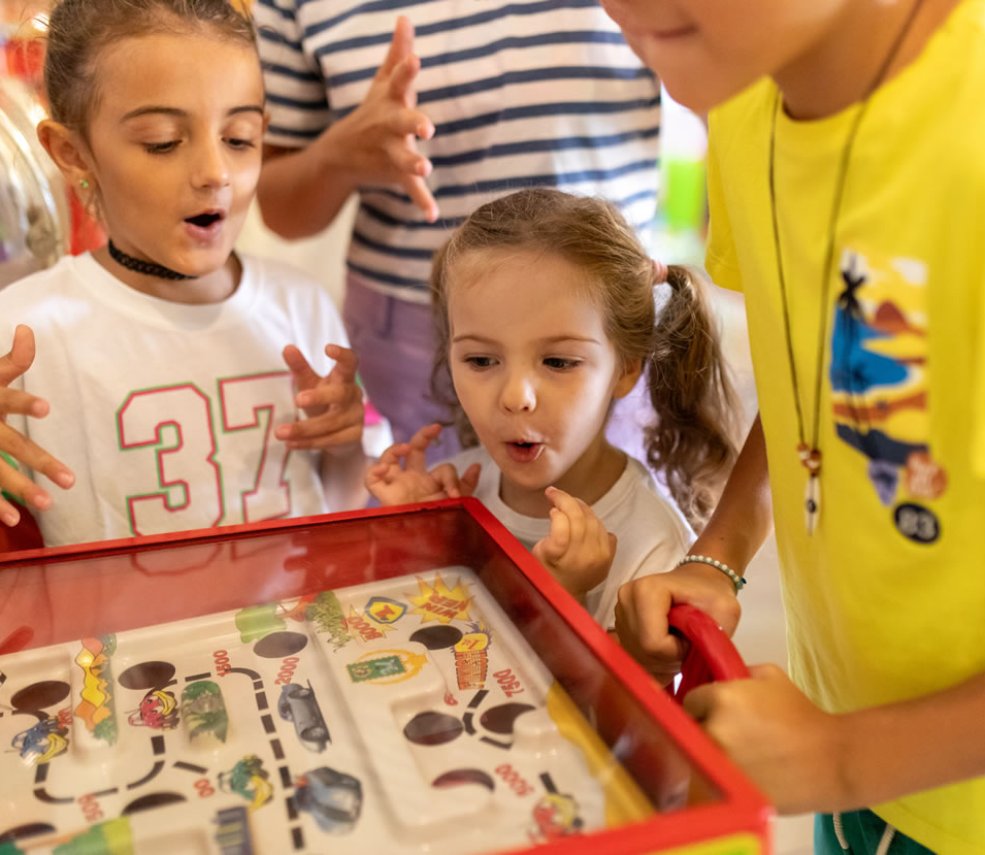 Bambini giocano con entusiasmo a un gioco da tavolo interattivo.